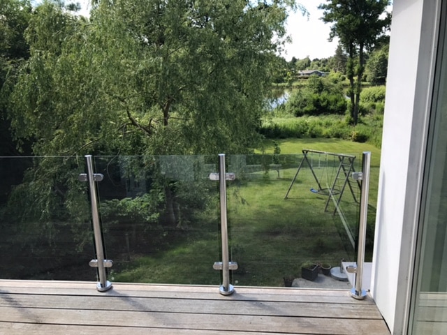 Glasgelænder med rustfrie balustre på hævet terrasse